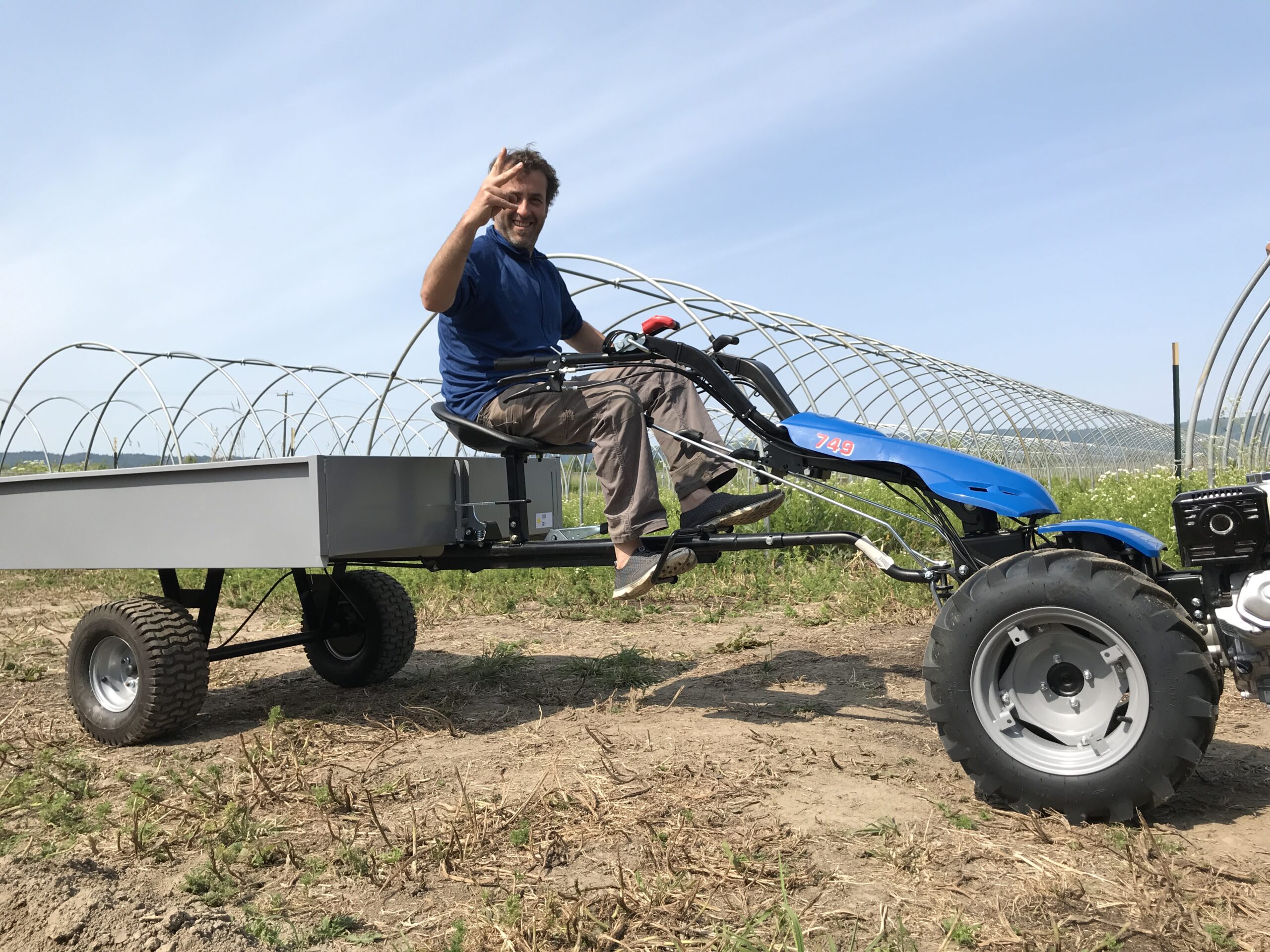 Igor Rakuz working at a farm with greenhouse structures behind him